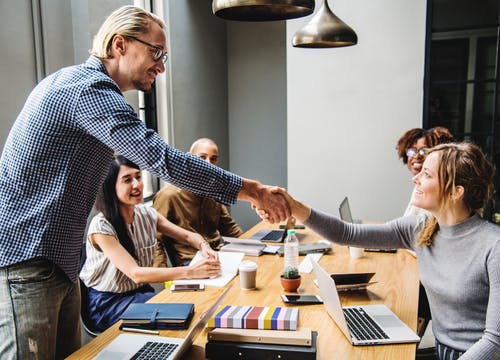 a man shaking hands with a womanin office